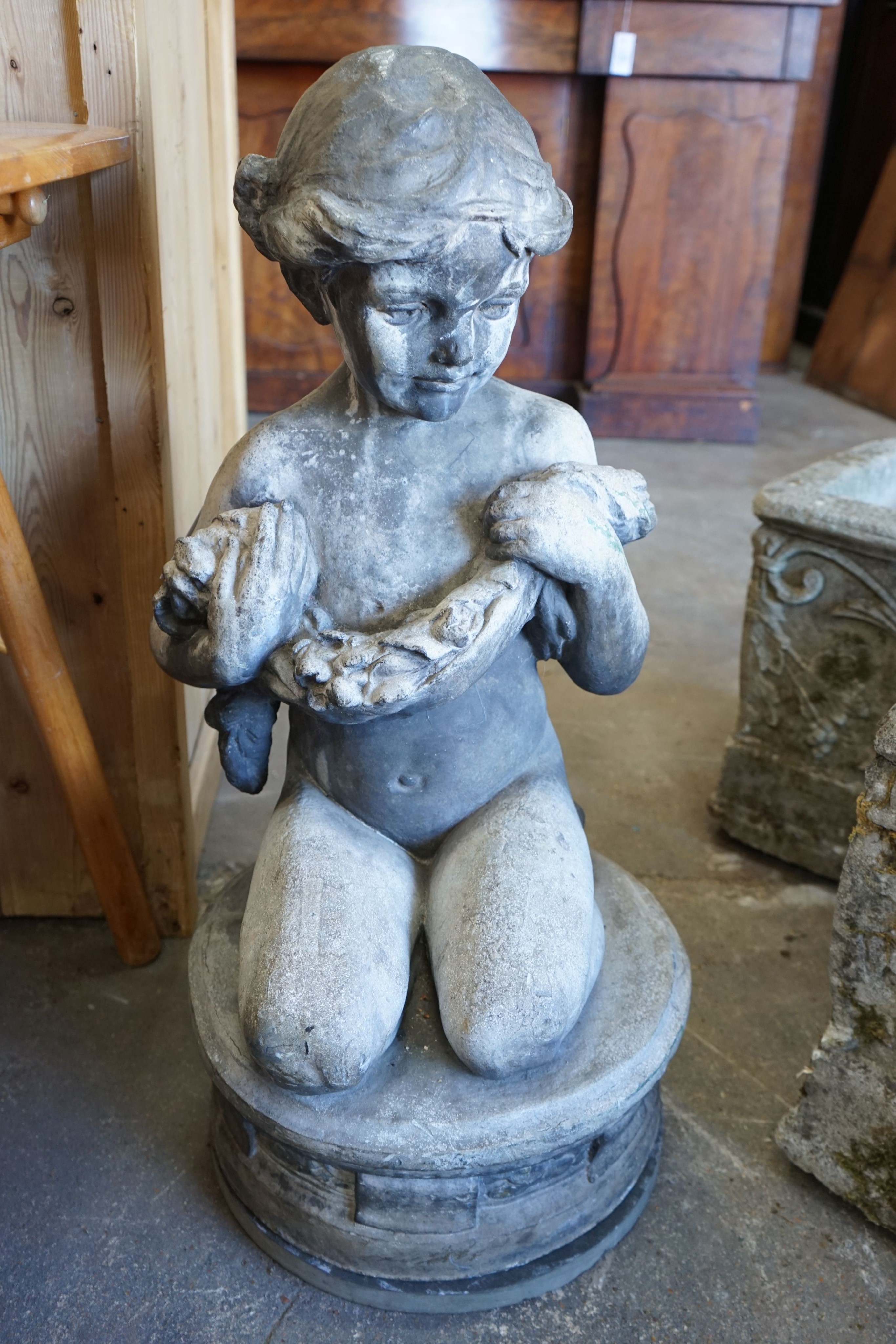 A lead garden ornament of a kneeling child with floral garland, signed Ruby Levick Bailey, 1909, height 74cm